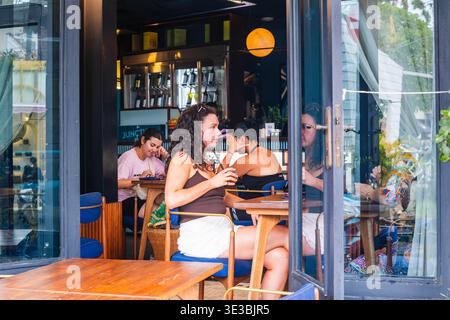Young Woman Relaxing at an Outdoor Cafe Table Stock Photo