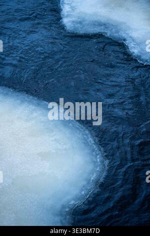 Curved deep blue frozen river with calm water Stock Photo