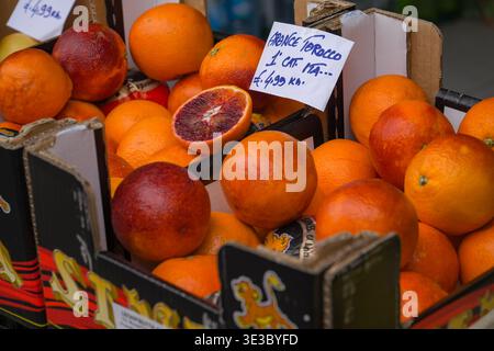 Moro Tarocco blood oranges at a produce stall in Rome, Italy. Fresh citrus fruit display with price sign. Stock Photo