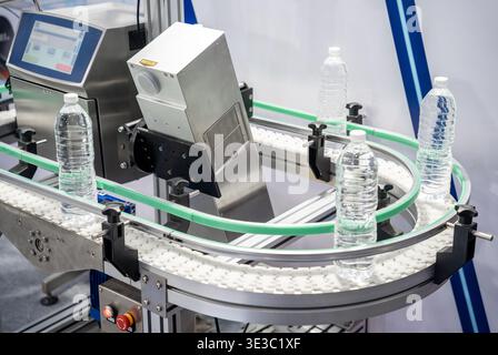 The hi-technology of drinking water manufacturing process. The empty drinking water bottles on the conveyor belt for filling process. Stock Photo