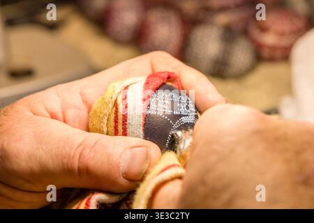 Schleife, Germany. 22nd Mar, 2026. A man uses a sharp tool to scrape paint from an Easter egg at the Sorbian Easter Egg Market, creating patterns on the shell. This weekend, the Sorbian Cultural Center will be transformed into a colorful marketplace for traditional and modern Easter egg art. More than 30 Easter egg artists will present their colorful works of art. Just as many traders sell their products on the open-air grounds of the cultural center. Credit: Frank Hammerschmidt/dpa/ZB/dpa/Ģ����ý Live News Stock Photo