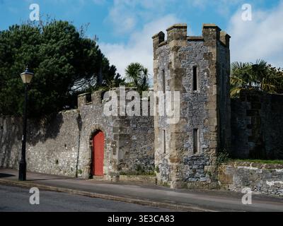 The Medieval castle walls in Arundel away from the main castle surrounding the gardens called the Stumpery with its impressive red gate and tower Stock Photo