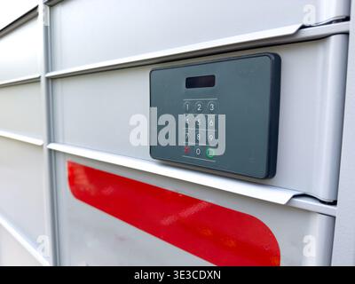 Close up view of a parcel locker keypad on a metal delivery locker,  modern logistics and security concept. Stock Photo
