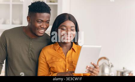 Happy African American Spouses Preparing Food In Kitchen And Using Digital Tablet Stock Photo