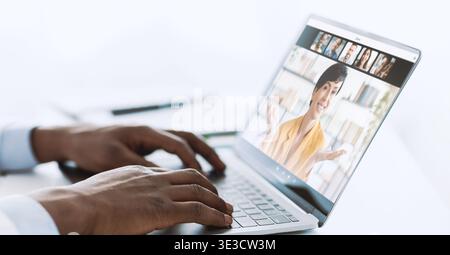 African American Male Doctor Using Laptop at Workplace for Virtual Consultations Stock Photo