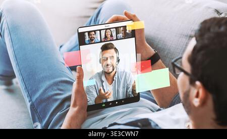 Young Man Searches for Jobs Online While Engaged in Video Call on a Tablet at Home Stock Photo