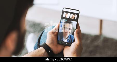 Man Using Cellphone for Online Shopping and Messaging in a Home Setting Stock Photo