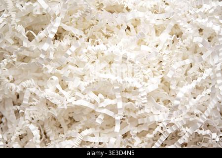 Shredded paper packing filler in white for gift box cushioning and protective packaging material Stock Photo