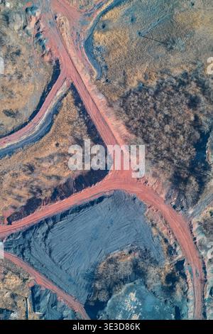 Java Asphelt Aerial view of an industrial site featuring large gravel piles, storage ...