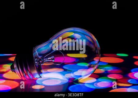 Modern light bulb glowing with refracted neon colors and copy space Stock Photo