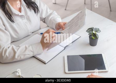 doctor reviewing medical report with tablet on desk representing healthcare analytics and digital medical workflow Stock Photo