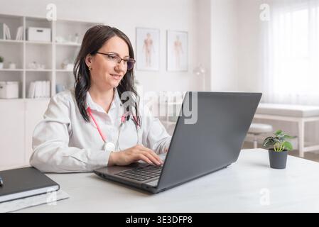 doctor working on laptop in clinic representing digital healthcare, medical data management and online consultation Stock Photo