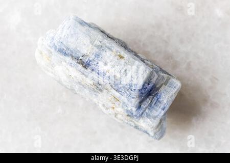 Close-up sample of rough kyanite rock on white marble background Stock Photo