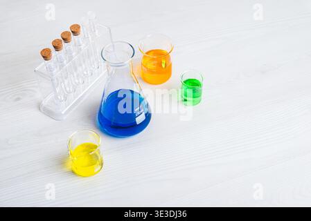 laboratory glassware with colorful chemical liquids on white background representing scientific research and chemistry experiments Stock Photo