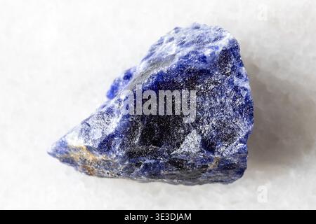 Close-up sample of raw sodalite mineral on white marble background Stock Photo