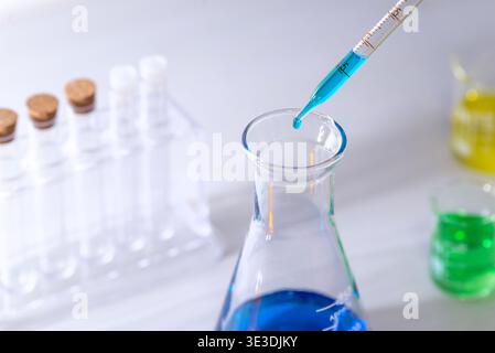 close up pipette dropping liquid into laboratory glassware in clean modern lab environment representing biotechnology and precision science Stock Photo