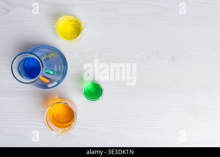 colorful laboratory liquids in glassware arranged on white surface representing chemistry research, innovation and scientific design concept Stock Photo