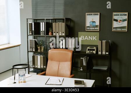 Empty Bank Branch Office Interior Featuring Desk and Organized Document Shelves Stock Photo