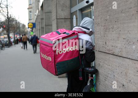 Foodora food delivery rider with branded backpack waiting on the street in Budapest, Hungary Stock Photo