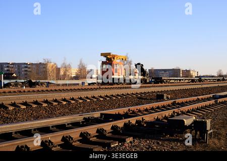 Railway track-laying crane positioned on the rails for infrastructure development. Specialized rail vehicle for lifting and placing sleepers and rail Stock Photo