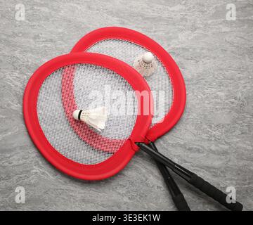 Badminton rackets and shuttlecocks on grey table, top view Stock Photo