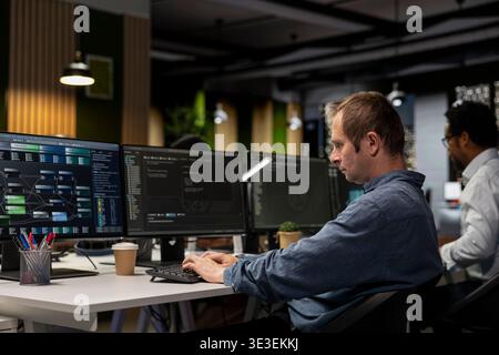 Computer scientist writing code, developing machine learning APIs. IT specialist in tech startup using PC to troubleshoot software errors using artificial intelligence, resolving system crashes Stock Photo