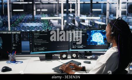 Data center software developer using AI assistant to provide user technical support. Server farm IT expert managing live support calls assisted by large language model chatbot, camera A Stock Photo