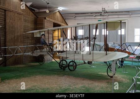 Somma Lombardo, Italy 24 Mar 23: Replica early 20th century biplane with pilot mannequin staged in a wooden hangar set at Volandia aviation museum nea Stock Photo