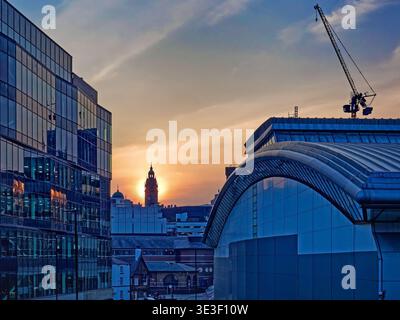 UK, South Yorkshire, Sheffield, Sun Setting behind Town Hall between Ponds Forge and Sheffield Digital Campus. Stock Photo