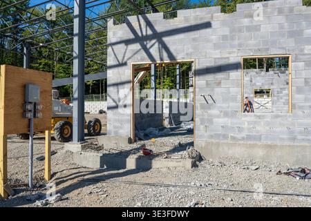 Concrete masonry unit, cmu, blocks wall under construction, with window and door openings. Stock Photo