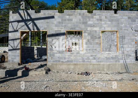 Concrete masonry unit, cmu, blocks wall under construction, with window and door openings. Stock Photo