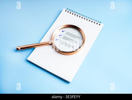Business audit and checklist review concept with magnifying glass over document. Compliance inspection, quality control, risk assessment, internal rev Stock Photo