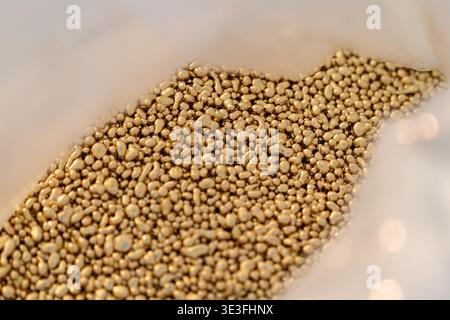 Brass metal granules stored in a plastic bag for industrial or manufacturing use showing raw material and material handling. Stock Photo