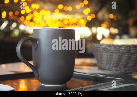 Warm cup of coffee on table at an outdoor cafe at night Stock Photo