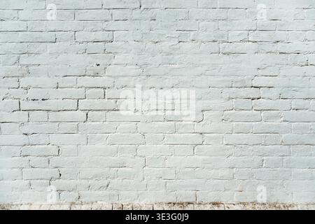 Whitewashed brick wall with subtle cracks and patina as background Stock Photo