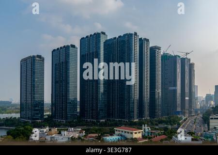 Modern high-rise buildings stand tall against a clear sky. Glass facades reflect the city's vibrant energy. Construction cranes hint at ongoing develo Stock Photo