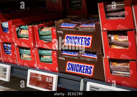 RIGA, LATVIA. 12th March 2026. Boxes of Snickers chocolate bars on a supermarket shelf. A close up view of Snickers candy bars in their iconic brown p Stock Photo