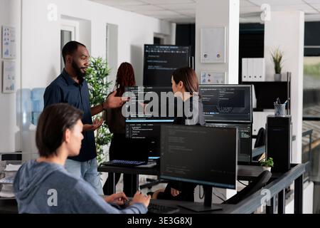 App software developer typing machine learning html code on computer, sitting at desk in it big data office. Cloud programer working on database system with coding script in software company, Stock Photo