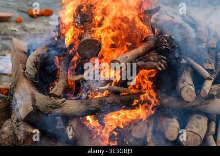 Detailed view of intense flames and charred wood within a cremation pyre at Lali Ghat in Varanasi, illustrating the ritual process on the bank. Stock Photo