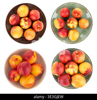 Large collection  overhead views of ripe nectarines and peaches served in various colorful ceramic plates and bowls. Vibrant red and yellow stone frui Stock Photo