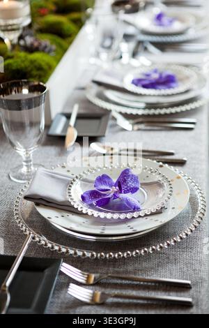 Elegant wedding place setting with purple orchid detail. Stock Photo