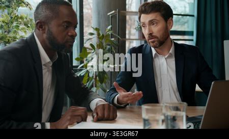 Two diverse multiracial businessmen business team in office development company cooperation work data discussing planning startup online project with Stock Photo