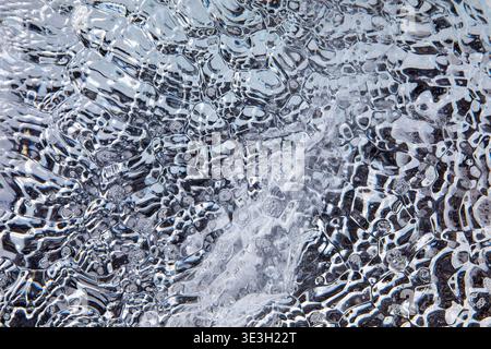 Abstract macro of air bubbles trapped in Arctic ice, forming a natural blue texture background, ideal for design, winter concepts, and environmental t Stock Photo