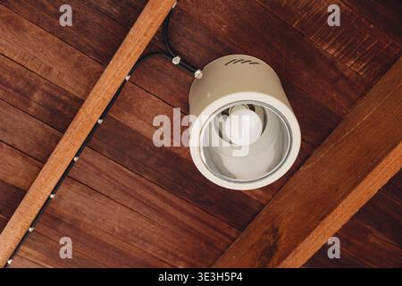 Ceiling lamp, Downlight mounted at wooden ceiling roof at home interior electricity modern design. Stock Photo