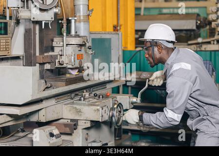Engineer technician African Black worker male working using Surface Grinding machine working in heavy metal industry factory Stock Photo