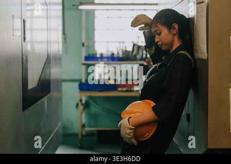 Tired woman worker hard working in heavy industry, Engineer labor female fatigue exhausted Stock Photo