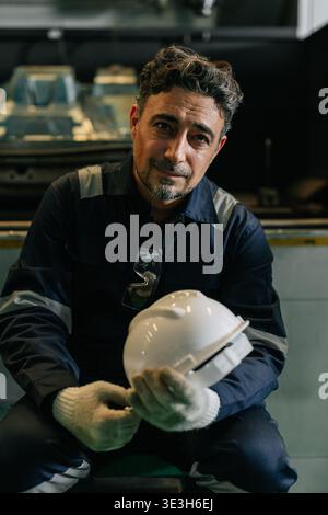 Mature Adult Worker Man, Professional Engineer Male, Technician in Industry factory sitting relax gentle smiling looking camera vertical Stock Photo