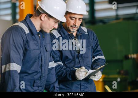 Senior engineer team with young worker help together checking list with sheet document report. Stock Photo