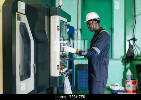 CNC Lathe Machine Engineer Operator Worker Working Entering Work Batch Production Program Data at Heavy Metal Factory Stock Photo