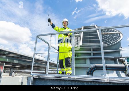 Professional Worker Servicing HVAC Modern office building Cooling tower, Industry Large Air conditioner system expert team service. Stock Photo